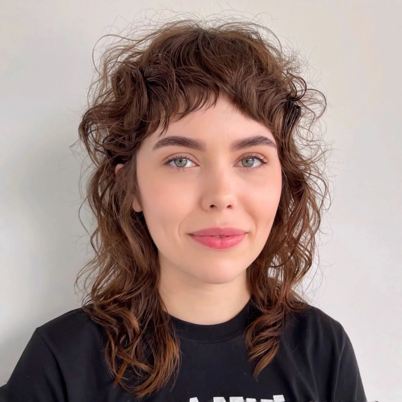 7. Curly Shag with Cropped Bangs (Medium Layered Shag)