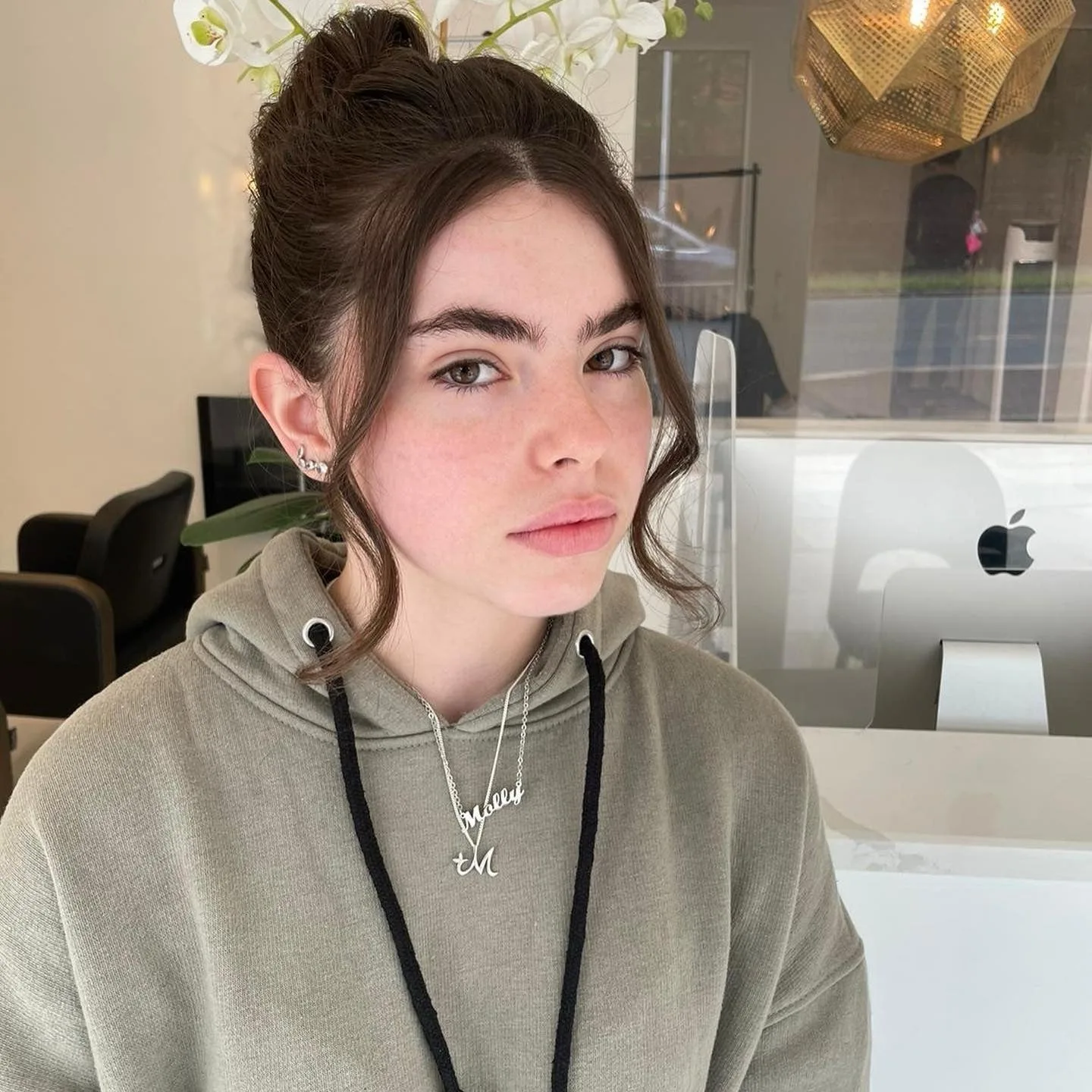 5. Glossy Brunette Bun with Face-Framing Curls (Top Knot Hairstyles)