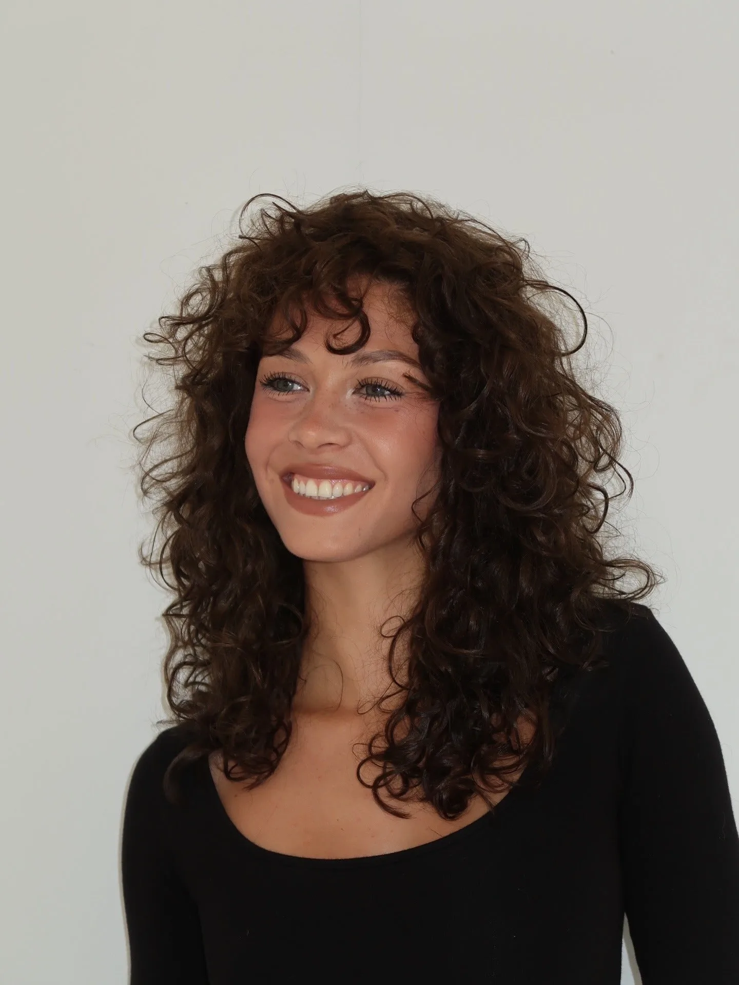 8. Bouncy Mid-Length with Textured Bangs (Wispy Bangs For Curly Hair)