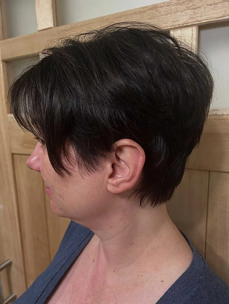 Dark black tapered bixie with feathered bangs side view