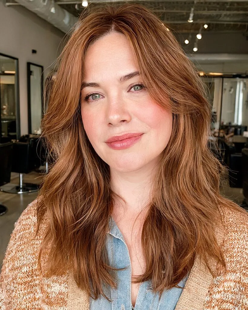 Medium copper brown haircut with soft face-framing layers and wispy ends for round faces over 40