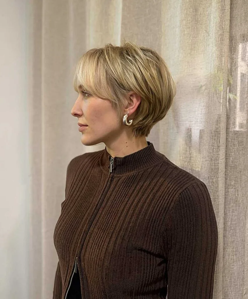 Polished blonde bixie with soft layers and side-swept bang