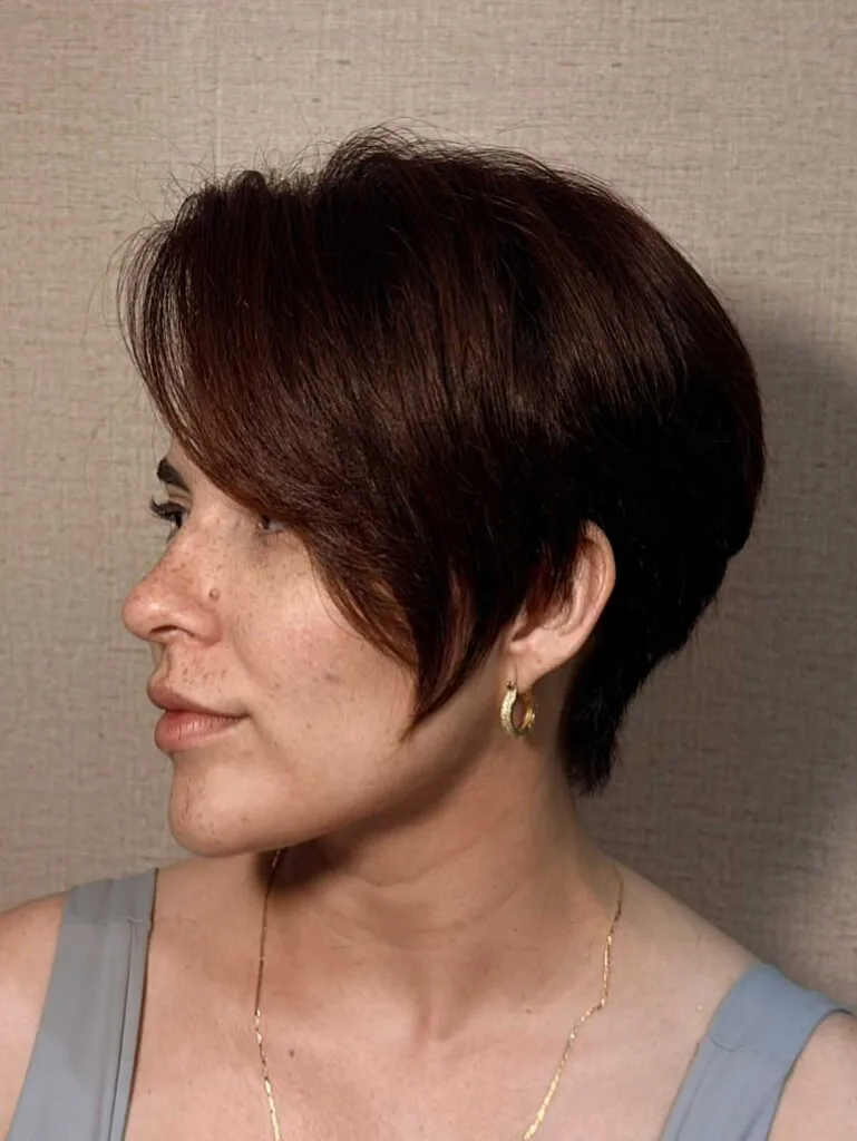 Rich brunette bixie with long side bang and tapered nape