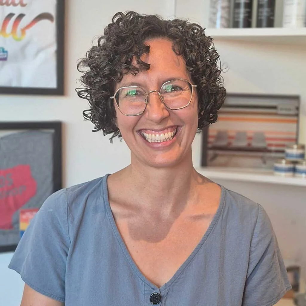Short dark curly bob with compact ringlets and glasses