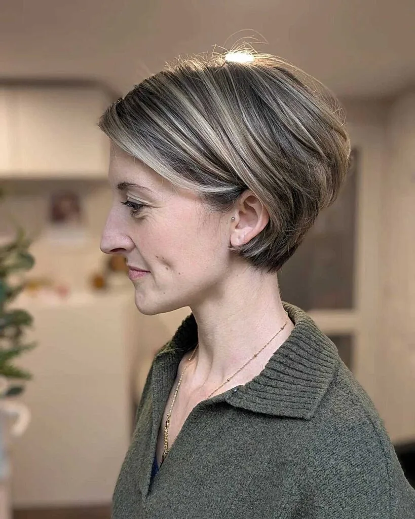 Sleek ash blonde bixie with gray blending and side part