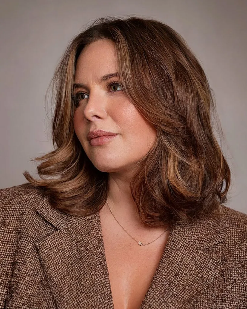 Textured medium-length haircut with curled ends and layered movement for women over 40 with round faces