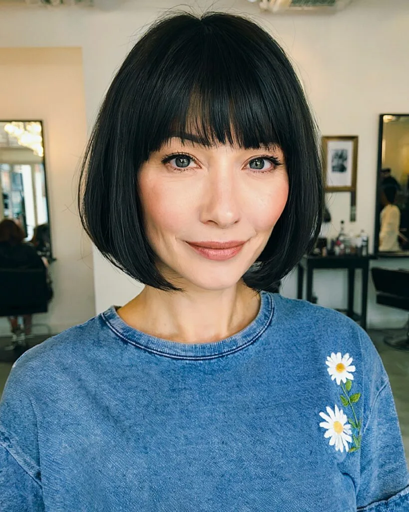 Classic bob with blunt bangs and soft face-framing layers for women over 40 with straight hair