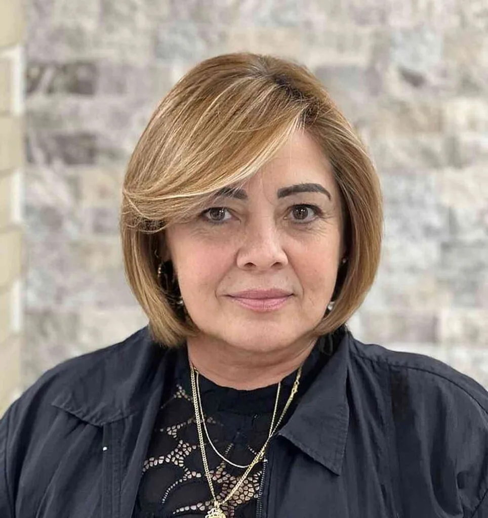 Jaw-Length Hairstyle Featuring Long Side-Swept Bangs and Bright Blonde Highlights for Women Over 50