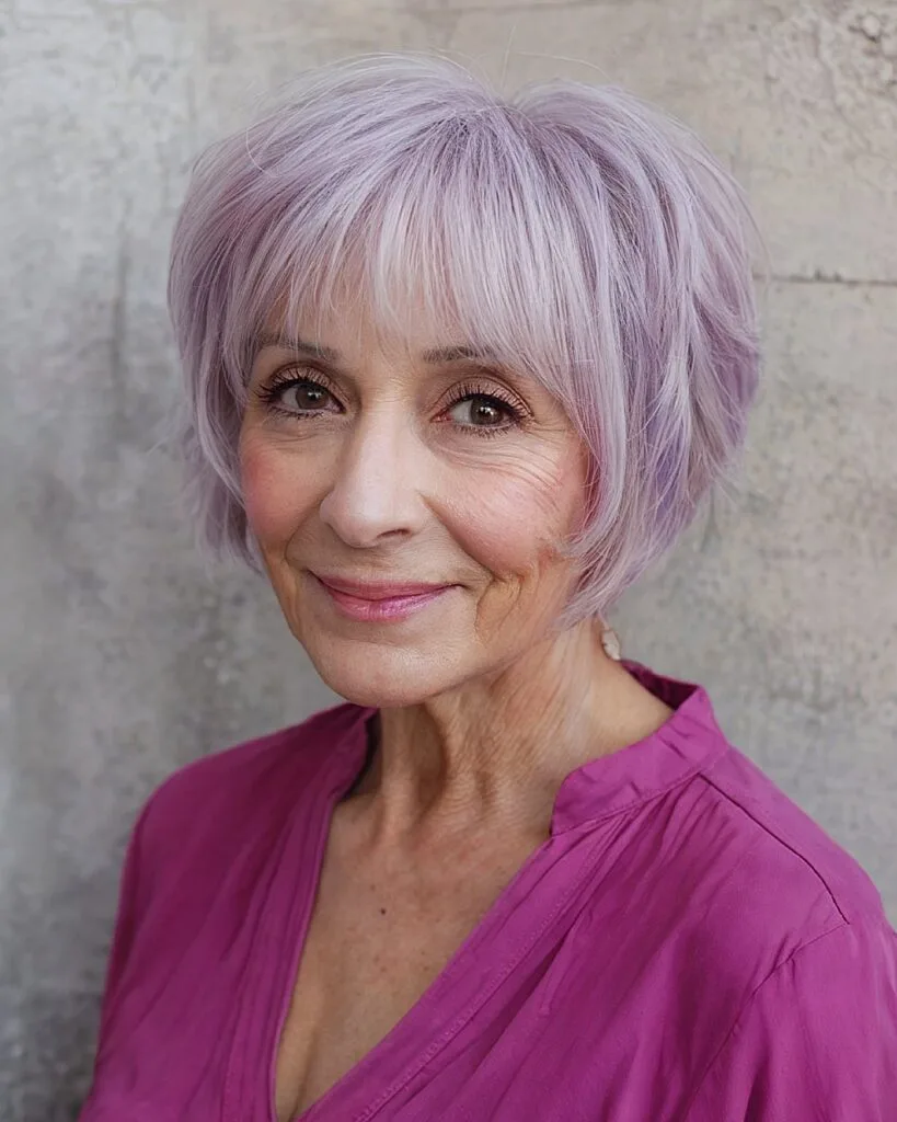 Razored shag haircut with lavender tint and soft fringe for women over 70