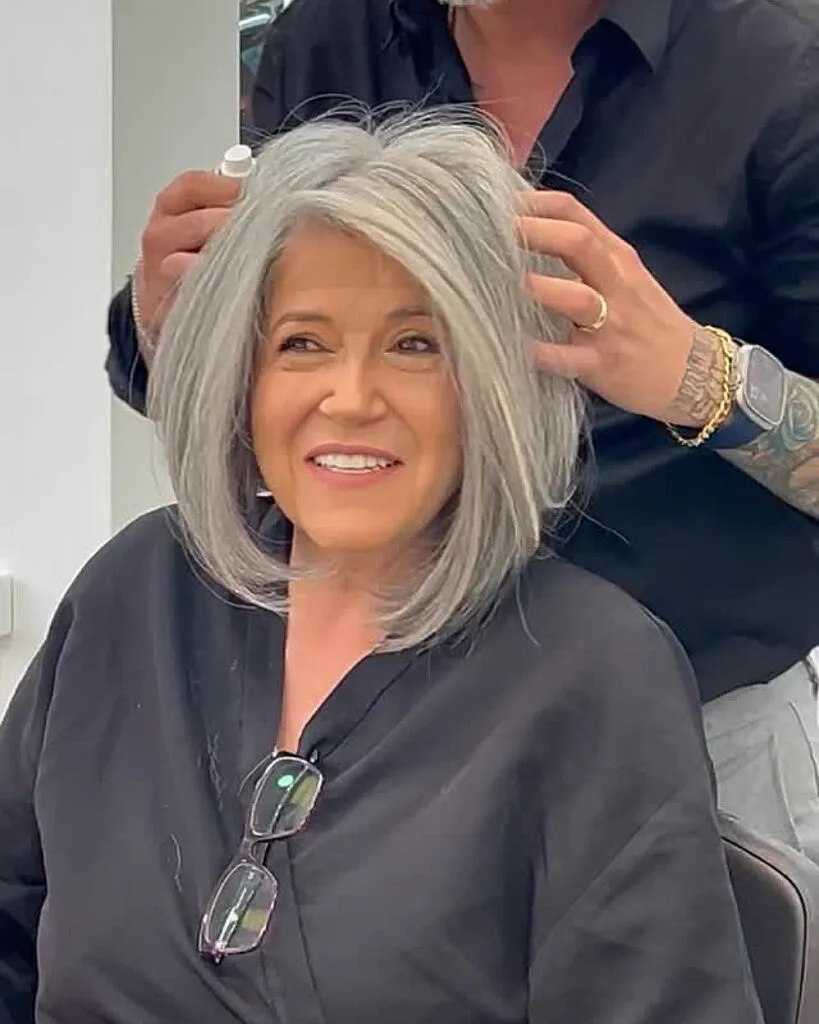Voluminous silver bob with layers for women over 60, styled to add fullness and movement to fine gray hair