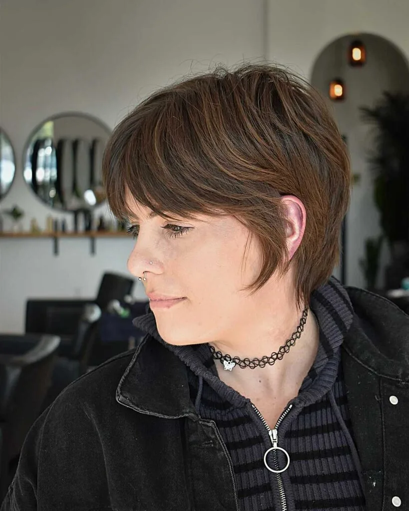 Brunette 90s grunge bixie with choppy bangs and layers
