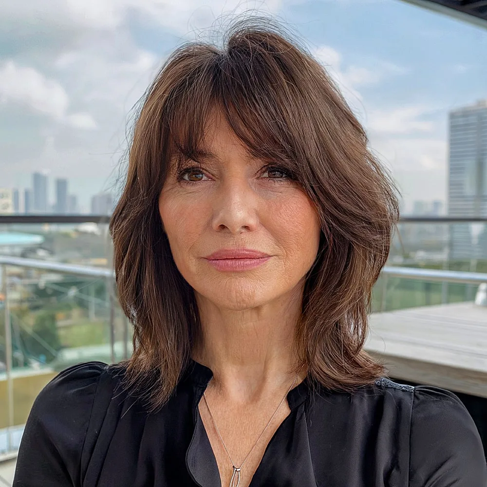 Chic long bob with fringe and layered brunette hair for women over 50