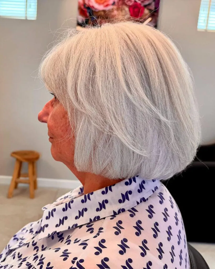 Classic silver bob with full fringe on straight fine hair, a timeless short bob haircut for older women