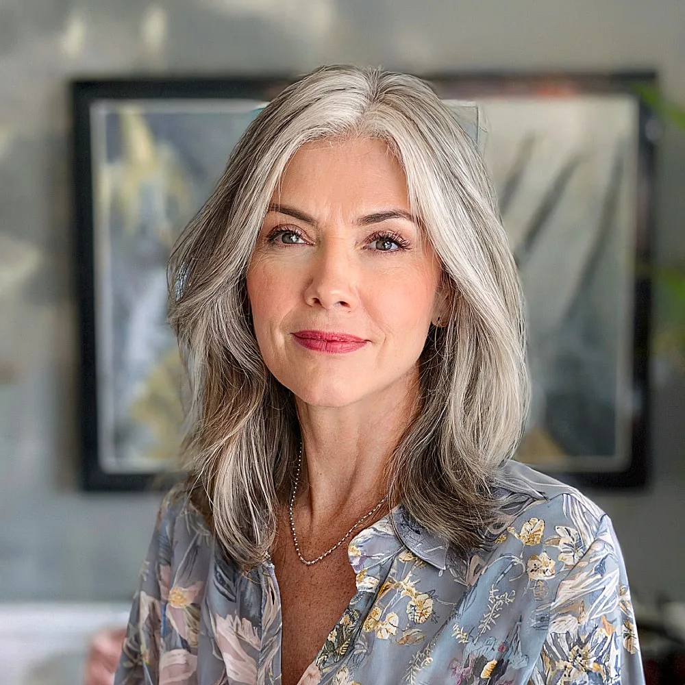 Collarbone-length gray lob with soft layers and a center part for older women
