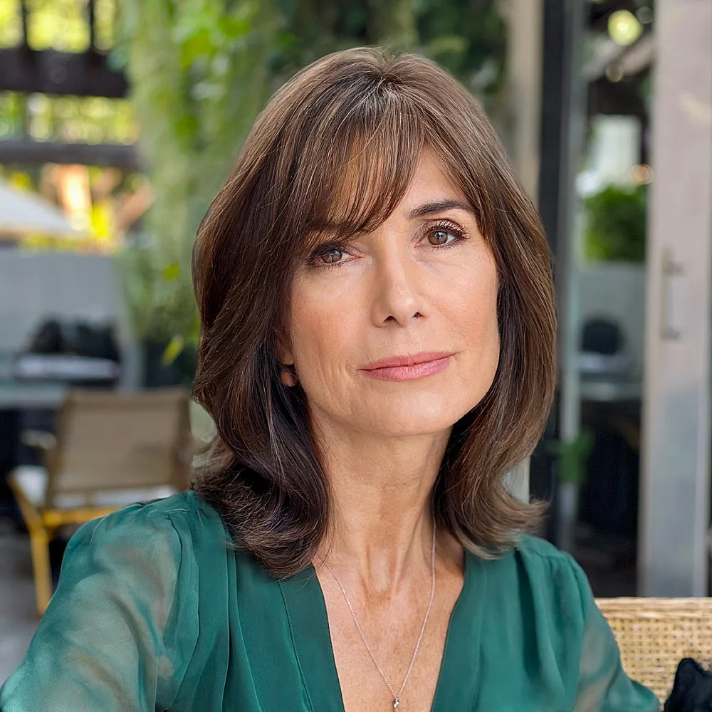 Layered long bob with side bangs and brunette color for women over 50