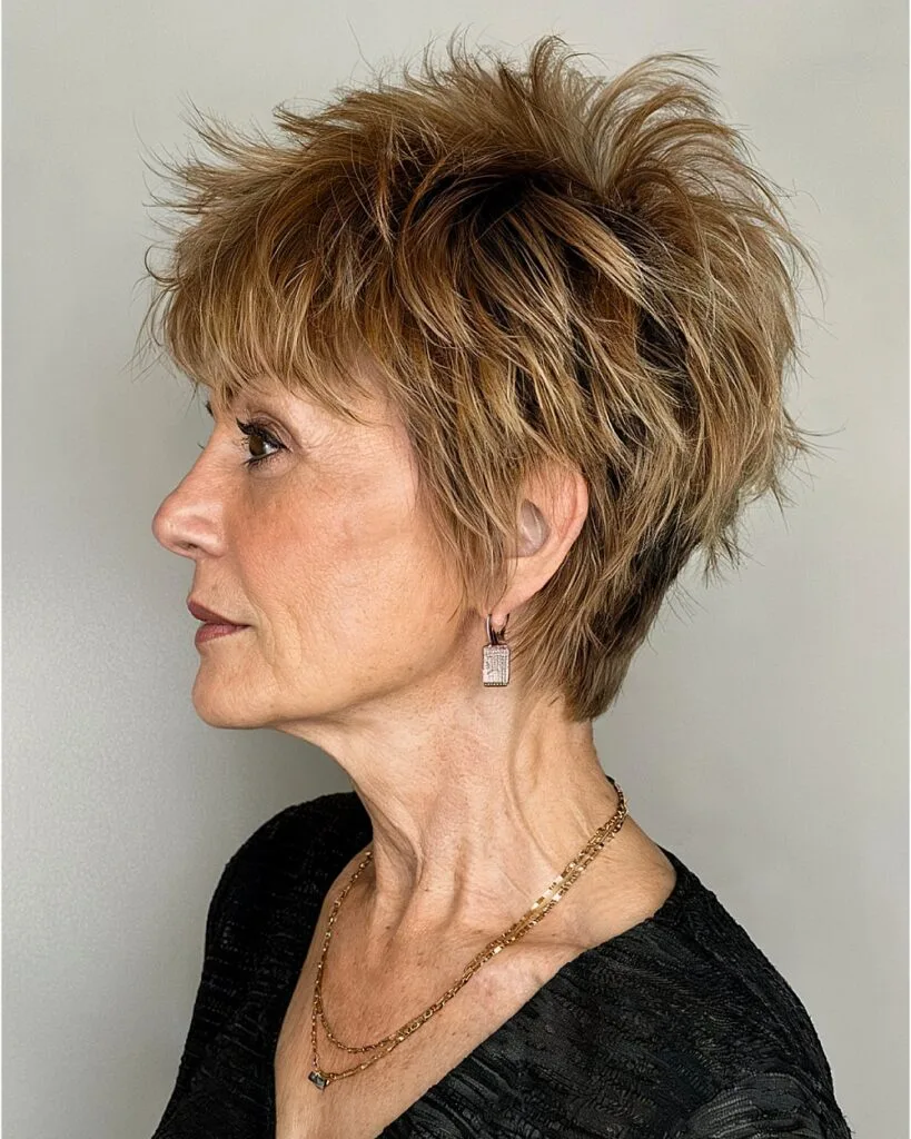Layered pixie shag for women over 50 with spiked crown volume and caramel brown tones