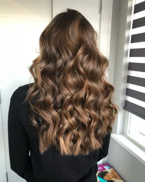 Medium-length layered silver-blonde hairstyle with soft waves for stylish women over 40
