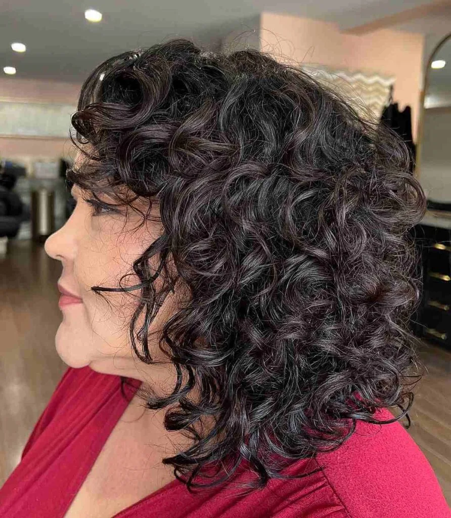 Shoulder-Length Curly Haircut with Curly Bangs for an Old Lady