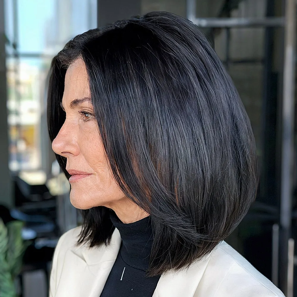 Sleek long A-line bob for women over 50 with dark brunette color and stacked layers