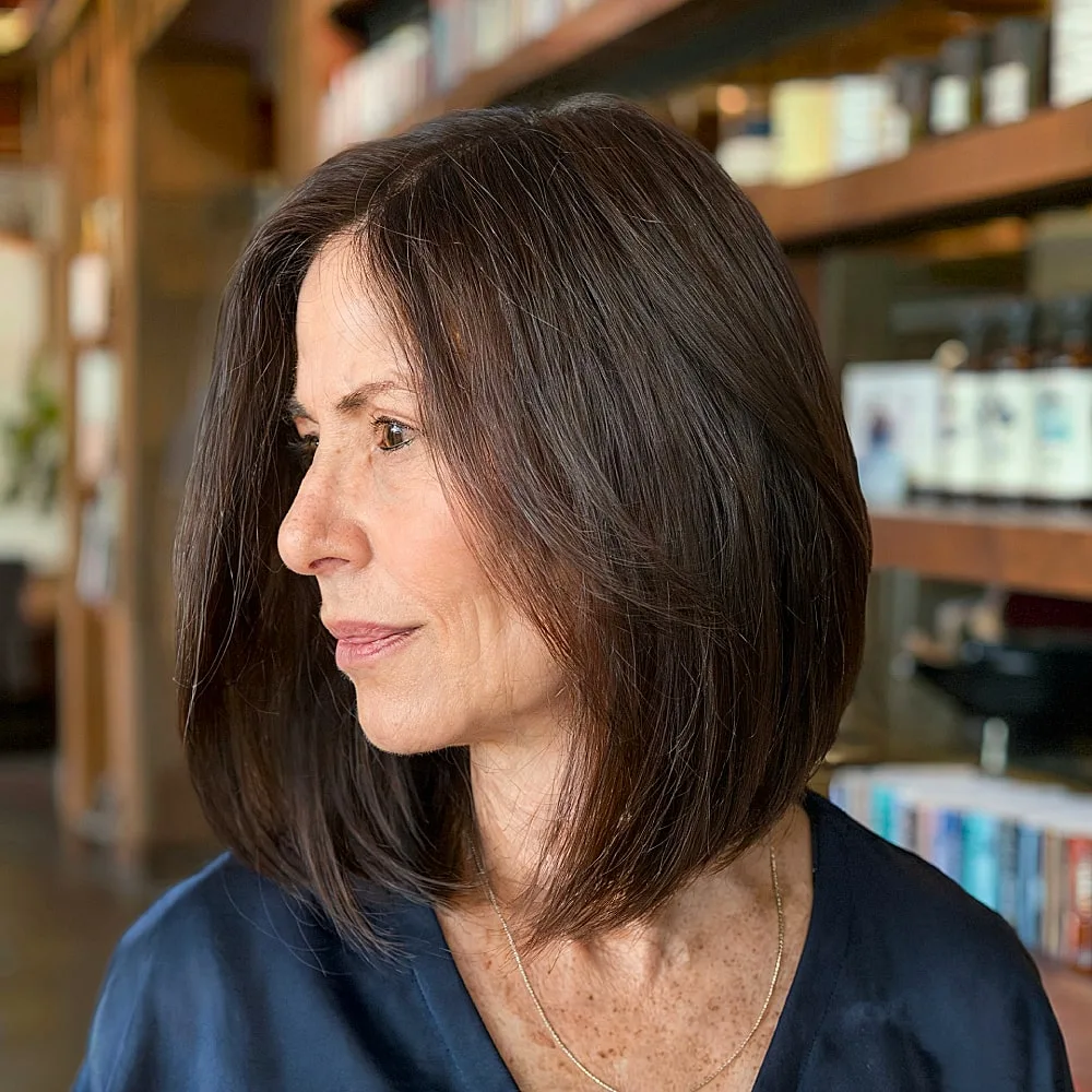 Sleek long inverted bob with layers and dark brunette color for women over 50