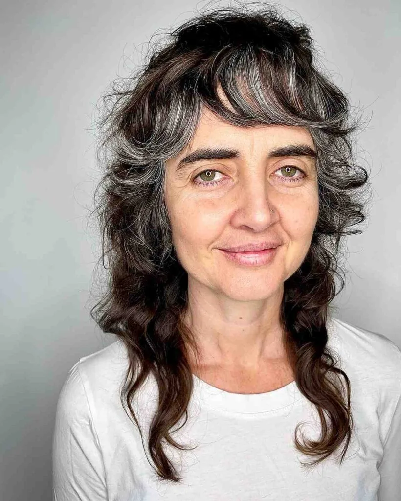 Stylish Medium-Length Curly Shag with Bangs for Dark Tresses