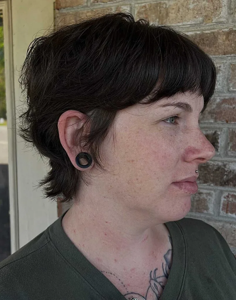 Black bixie mullet hybrid with short bangs and nape length