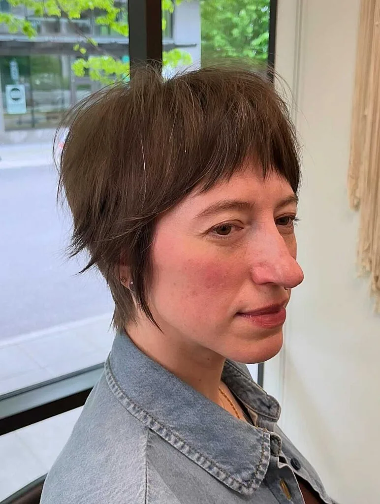 Brunette shaggy bixie with long wispy fringe and layers