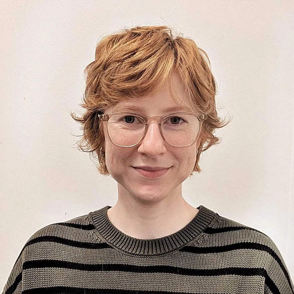 Copper red wavy bixie with tousled volume and glasses