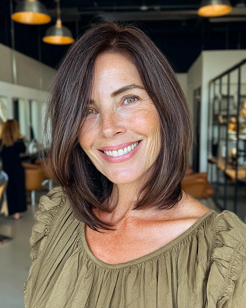 Minimalist straight long bob for women over 50 with deep brown tones and blunt ends