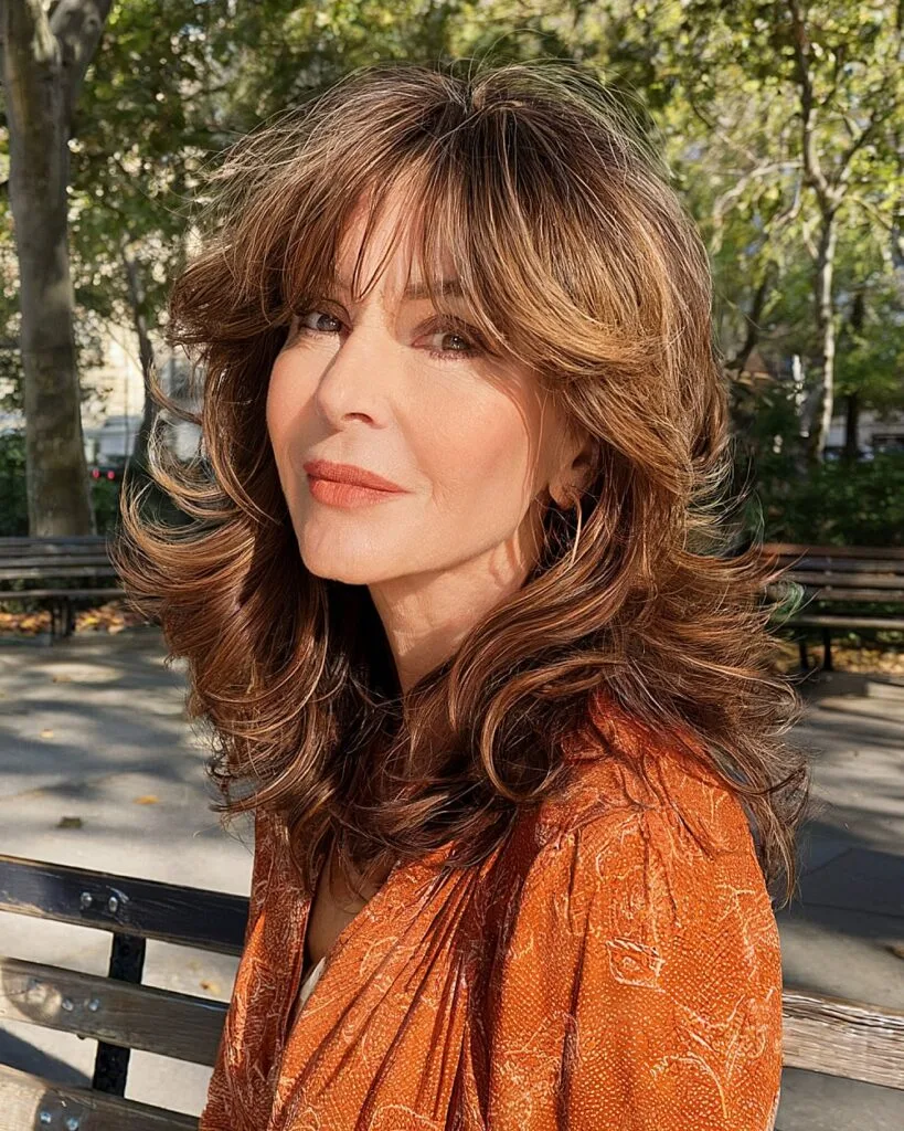 Modern 70s-inspired shag haircut with layered waves and soft bangs for women over 50