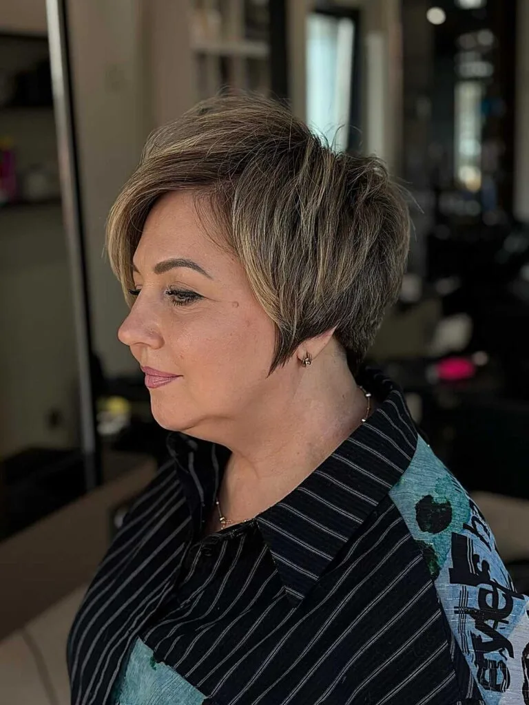 Polished brunette bixie with caramel highlights swept back