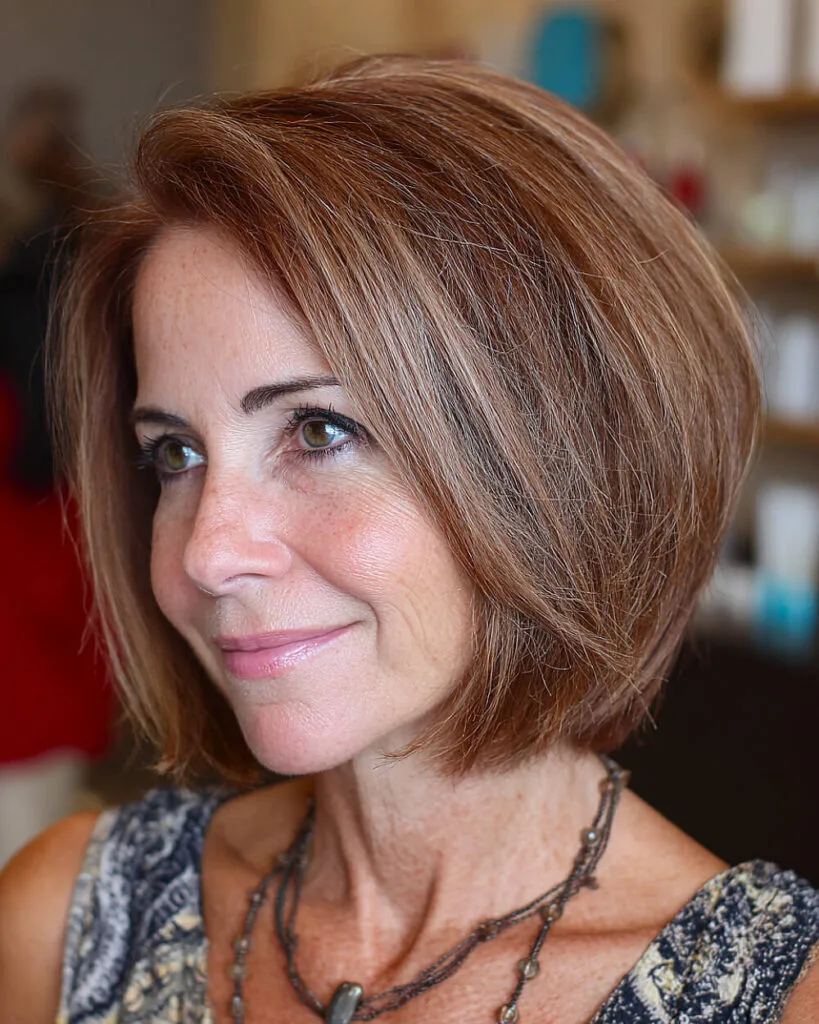 Straight choppy long bob for women over 50 with rich auburn tone and flipped ends