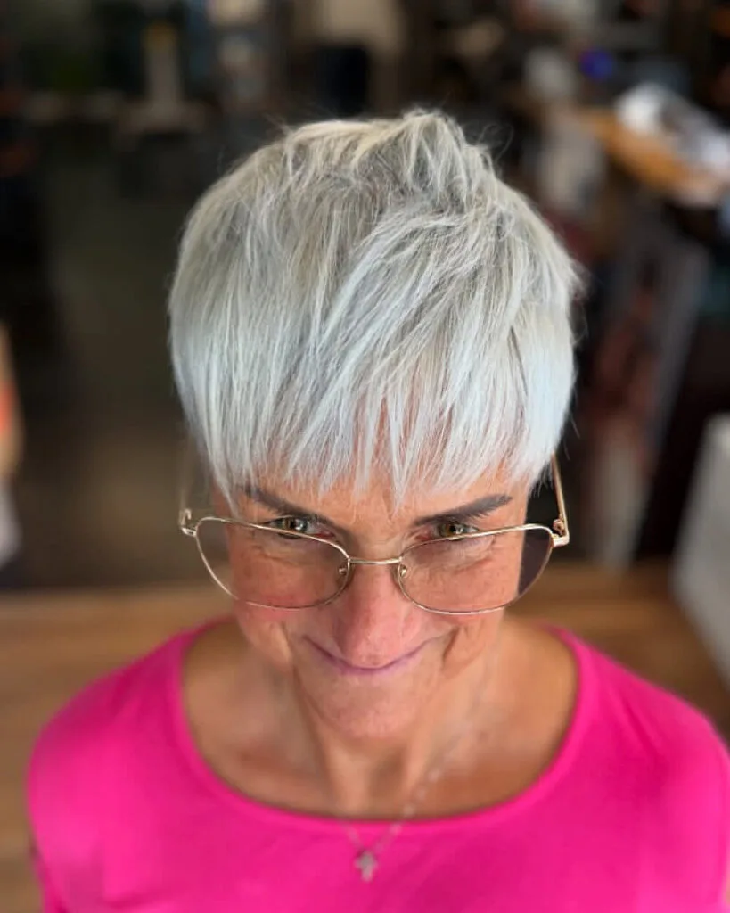 Textured silver pixie with bangs for women over 70 featuring layered crown and wispy fringe