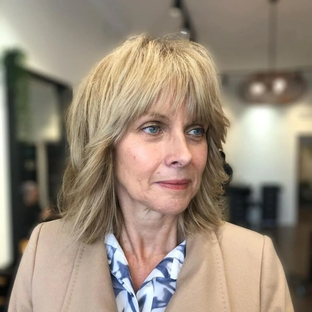 Chic medium-length haircut with bangs and layers for women over 60