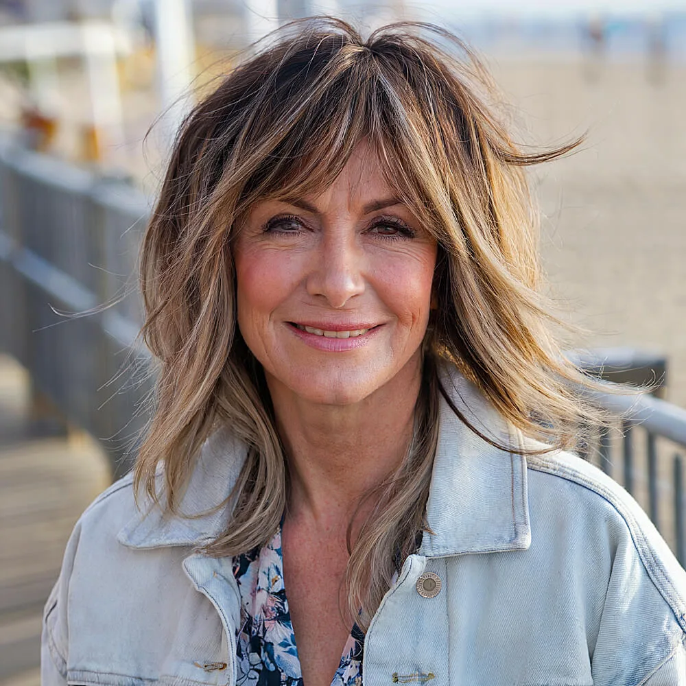Medium-length shag haircut with messy layers and wispy fringe, ideal for a carefree and youthful look
