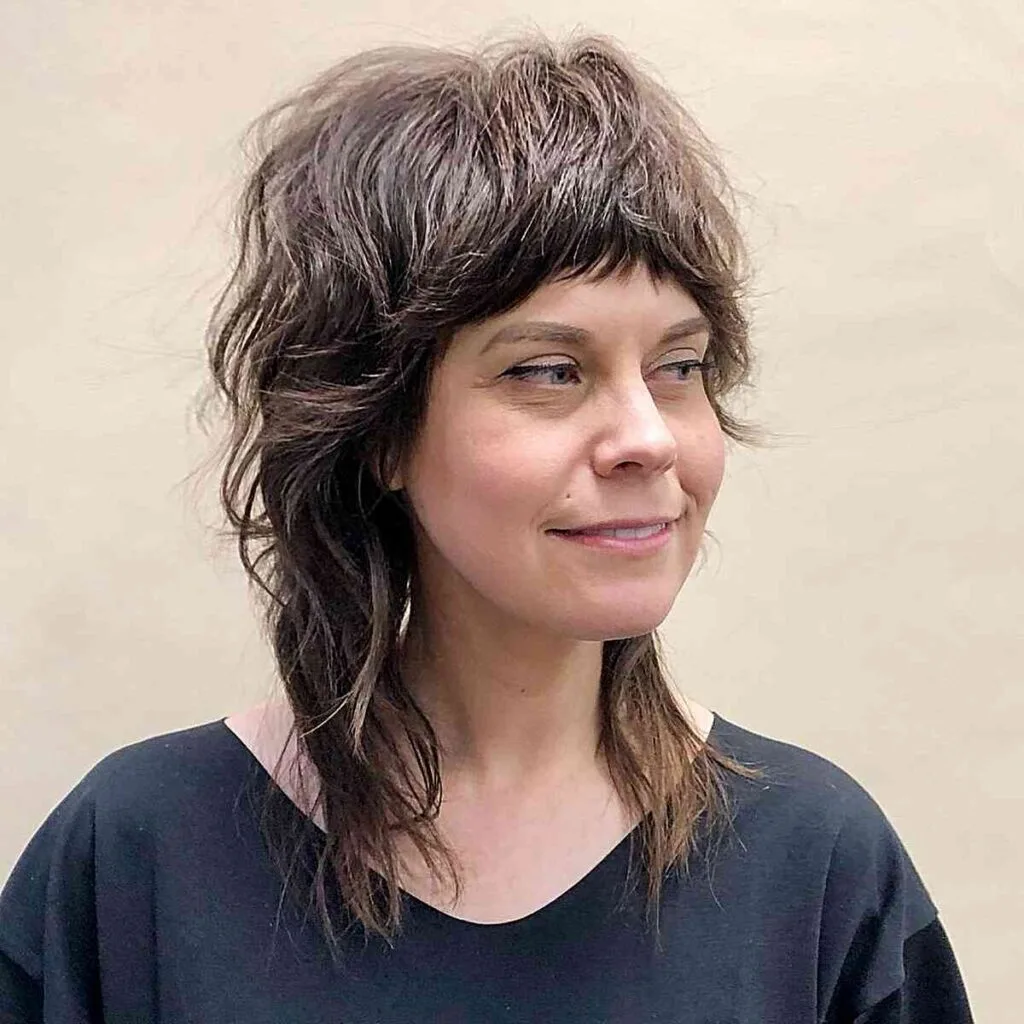 Medium Shag Shullet featuring textured razor cut layers and bangs for women over 40