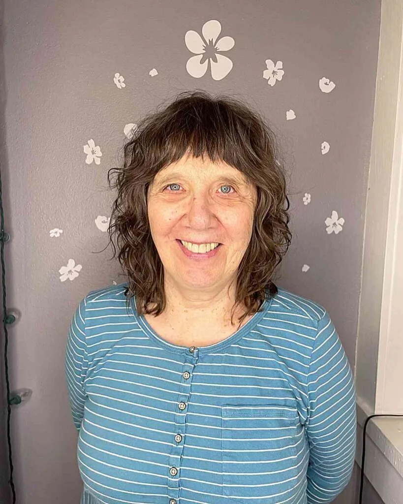 Short-Length Brunette Shag with Loose Curls and Mini Bangs for Older Ladies