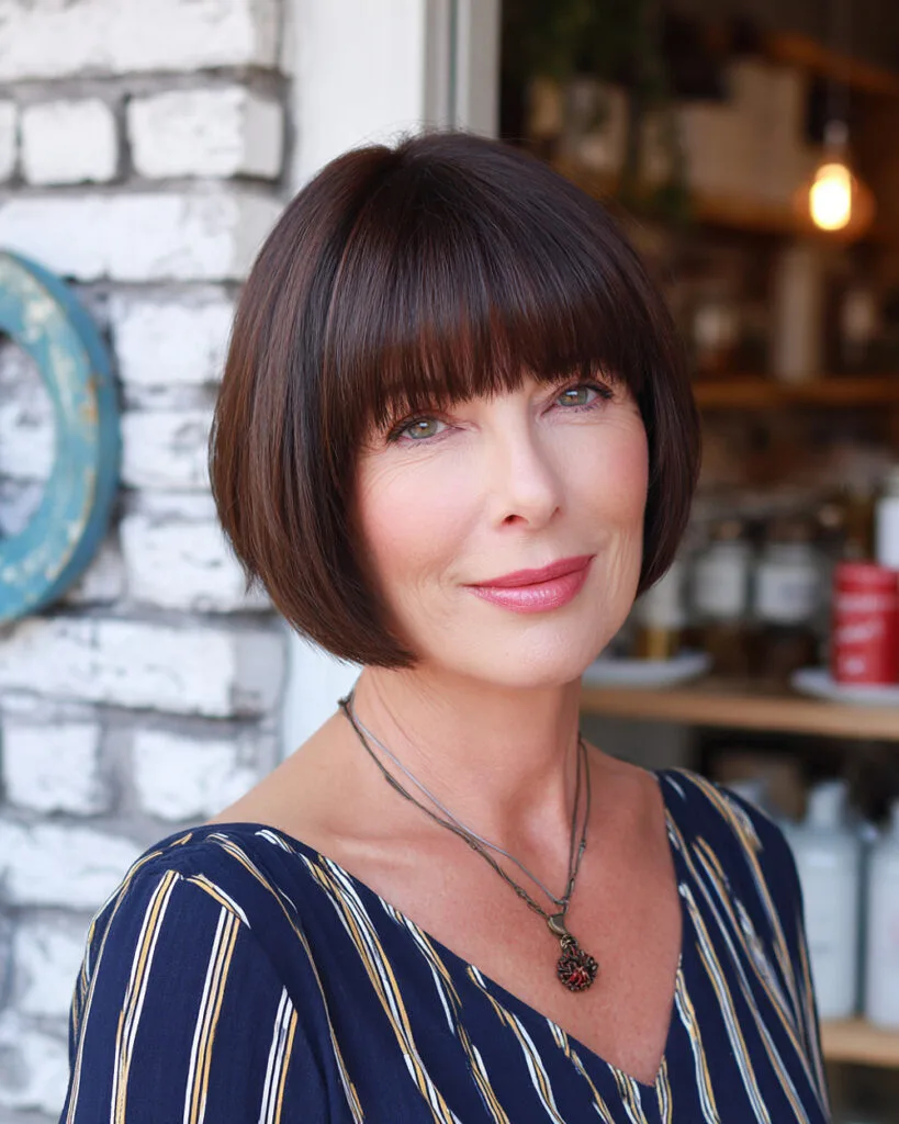 Short sleek French bob with blunt bangs for older women with thick hair
