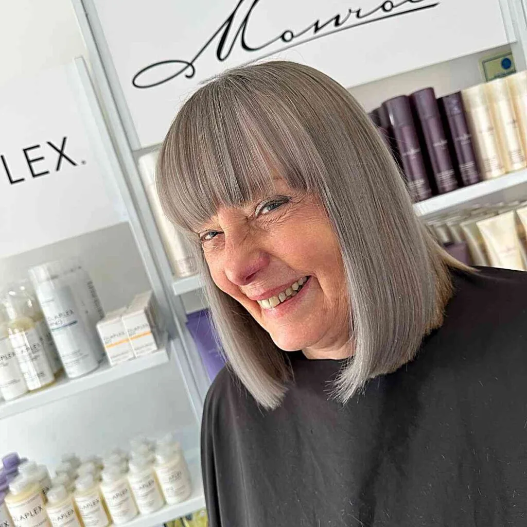 Sleek Grey Lob Cut with Full Bangs on Older Women Over Fifty