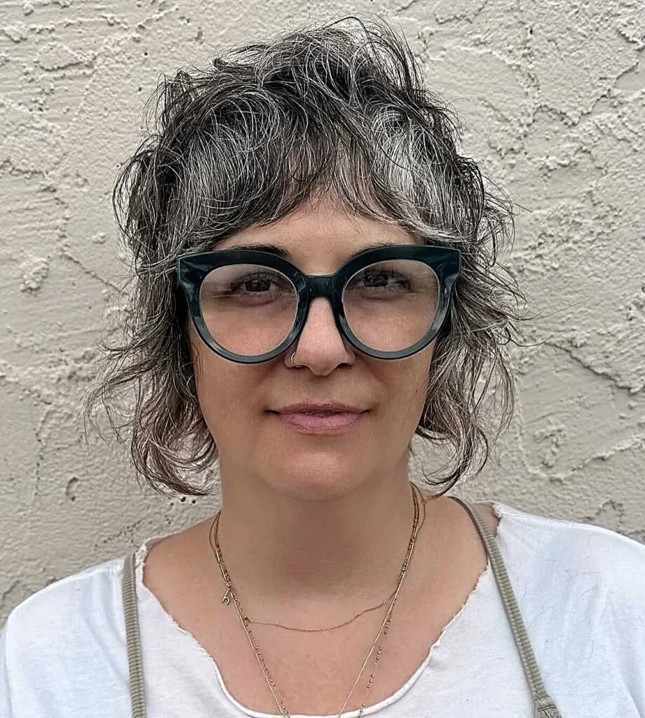 Curly dark gray bob shag with oversized glasses