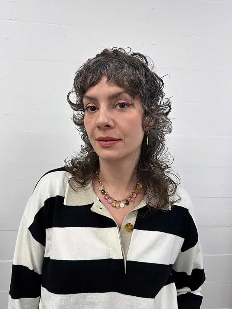 Curly gray shoulder-length shag with wispy bangs
