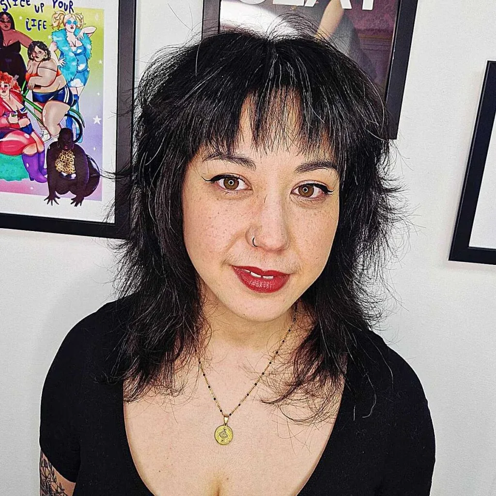 Jet black chin-length textured shag with blunt bangs
