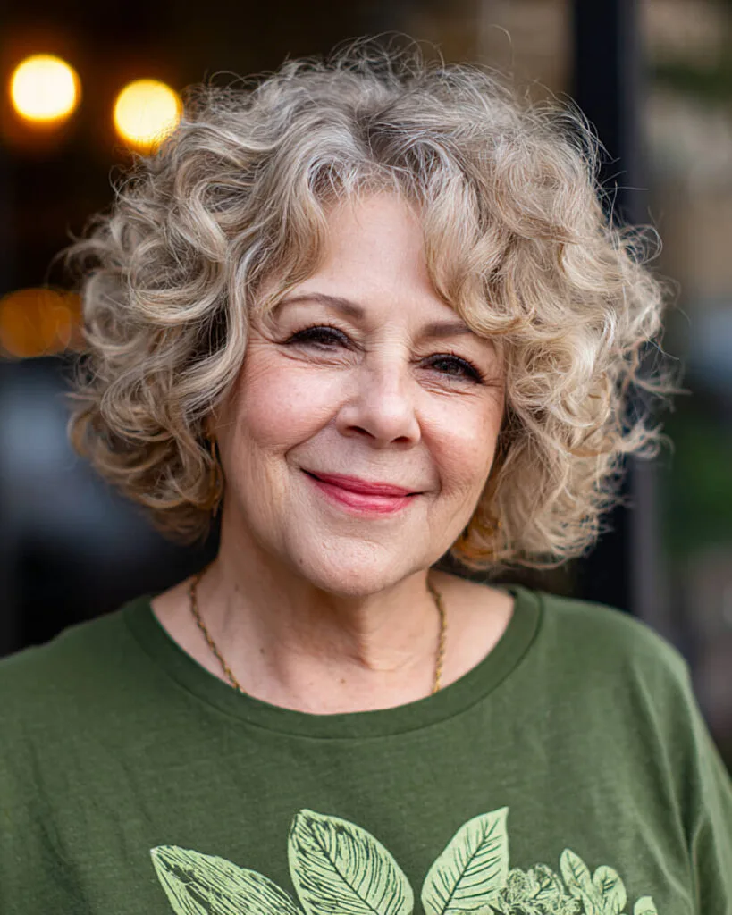 Tight curly bob with enhanced volume on a confident older woman