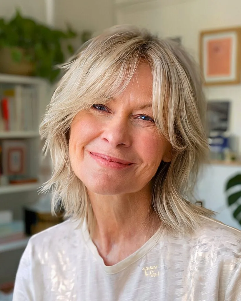 Blonde shaggy bob with soft texture and piece-y fringe for fine hair over 50