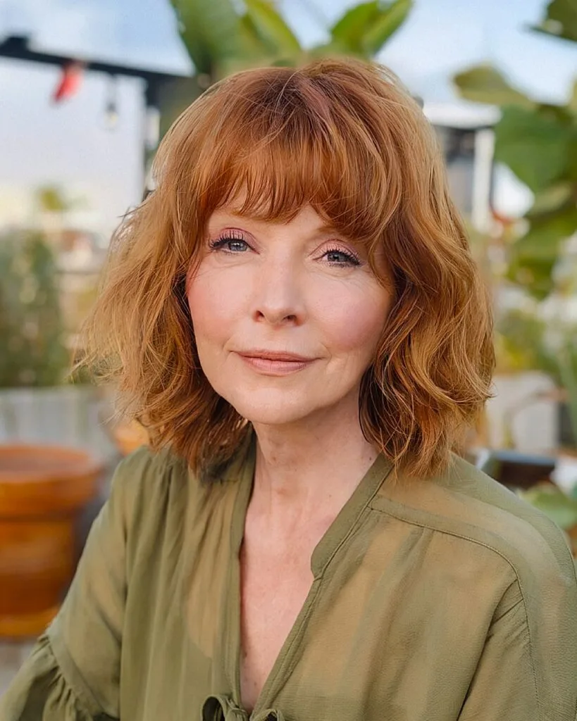 Copper shaggy bob with bangs and face-framing layers for fine hair over 50