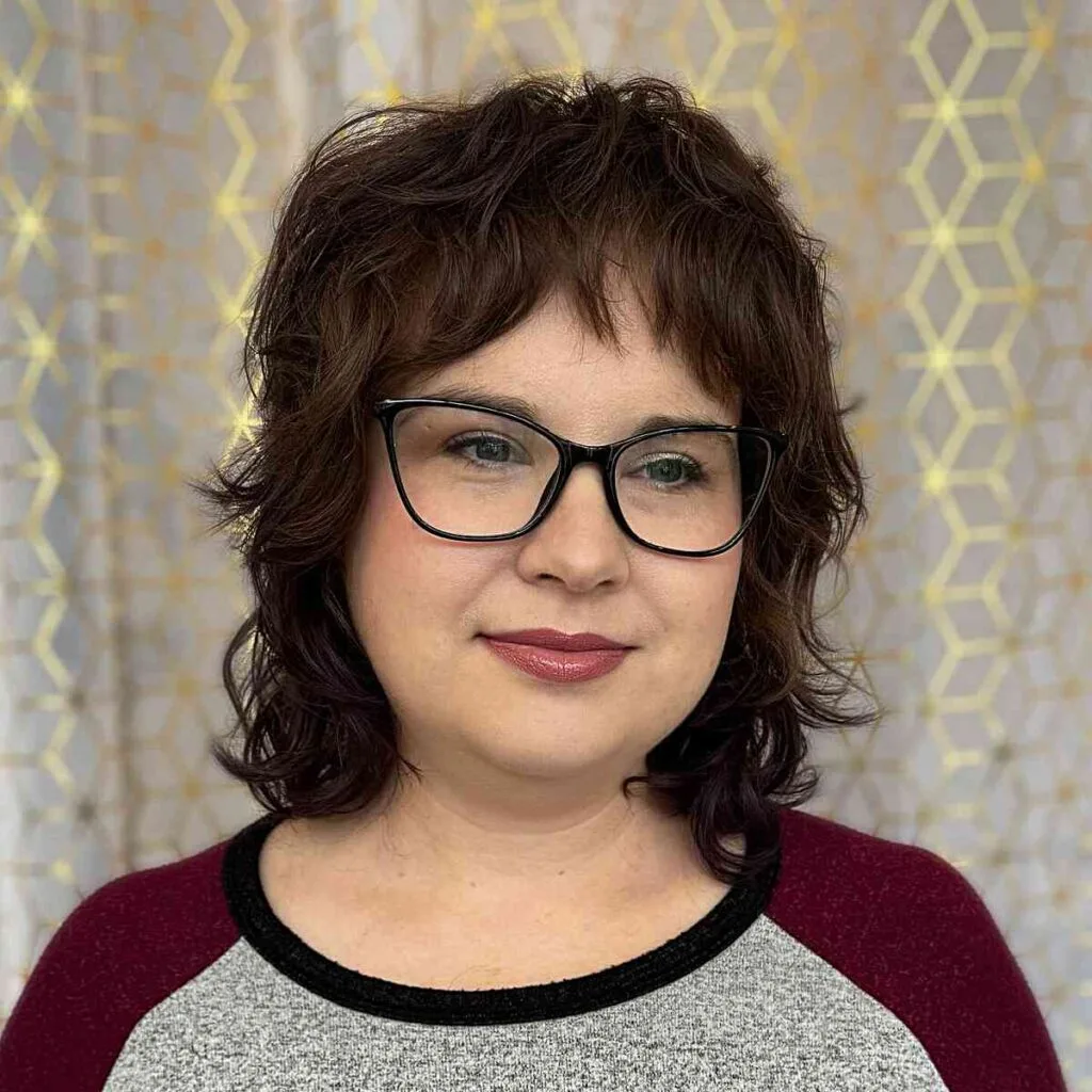 Shoulder-Length Shaggy-Mullet Style with Baby Bangs for Women Over 40 with Glasses