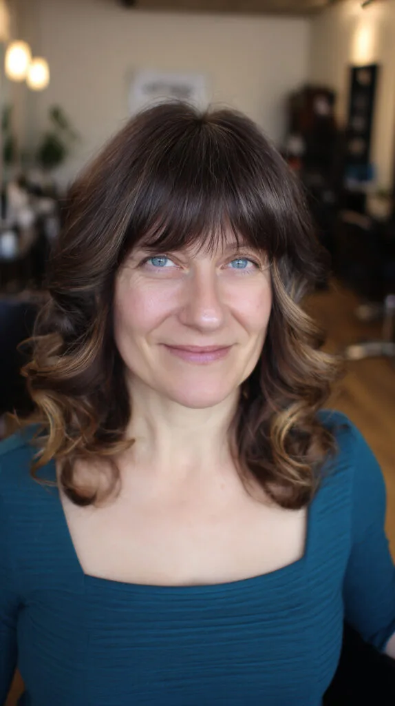 Softly Layered Curls with Wispy Bangs for a Flattering Frame