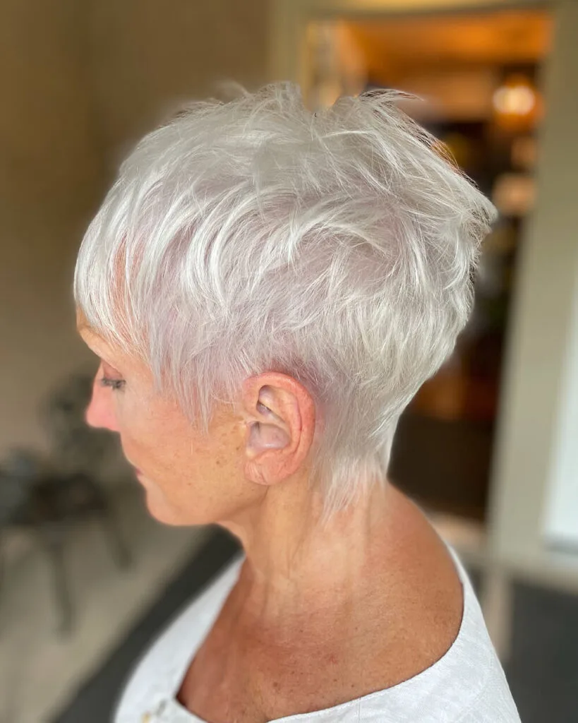 Textured platinum pixie cut for women over 60 with wispy layers and tapered nape for fine white hair
